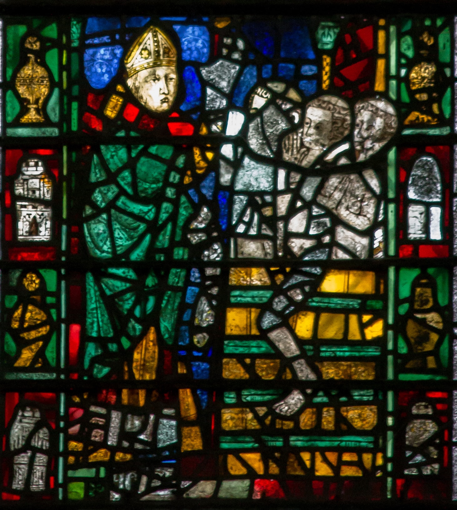 Medieval stained glass panel with lead lines, painted faces and yellow silver stain