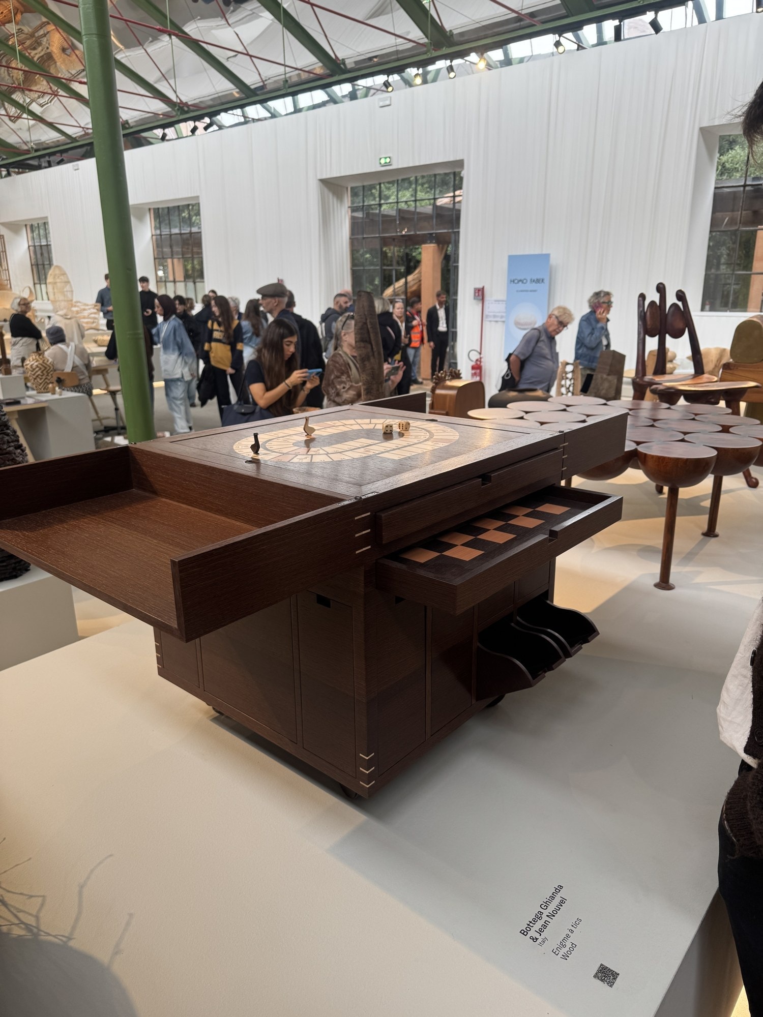 A dark wood games table with drawers pulled out to show a chessboard and a race-track board on top