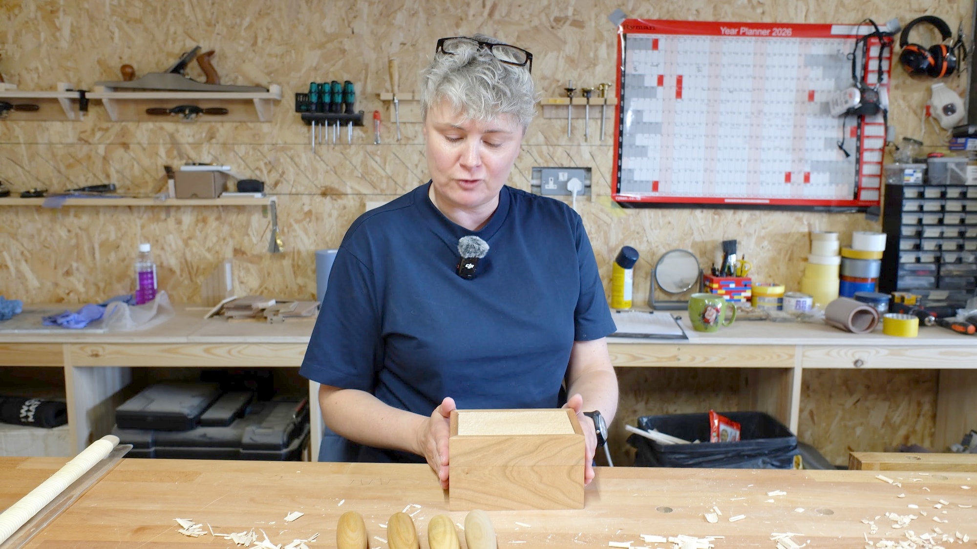 Claire Broad at her workbench holding a wooden box