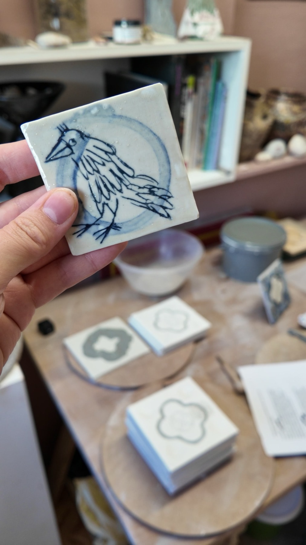 A small square tile with a blue rook inside a pale blue ring, held in a hand