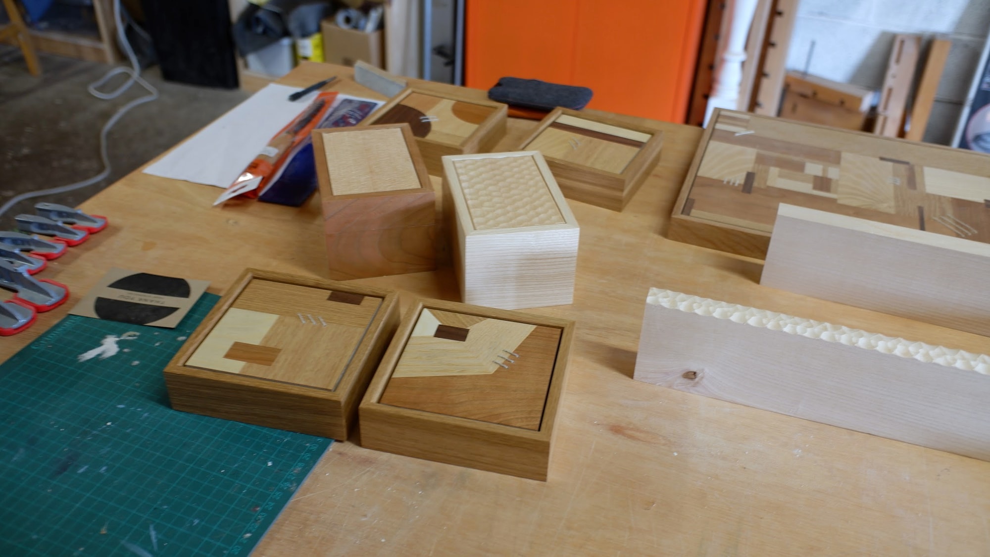 Finished boxes and small pieces with geometric marquetry tops on Claire Broad's bench